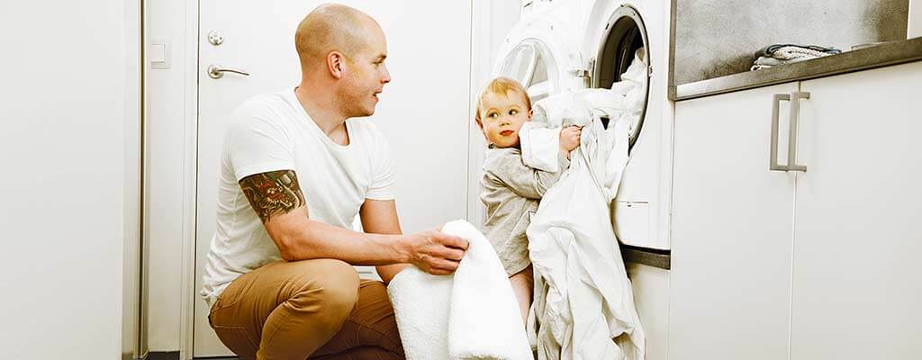 Vater und Kinder machen die Wäsche.
